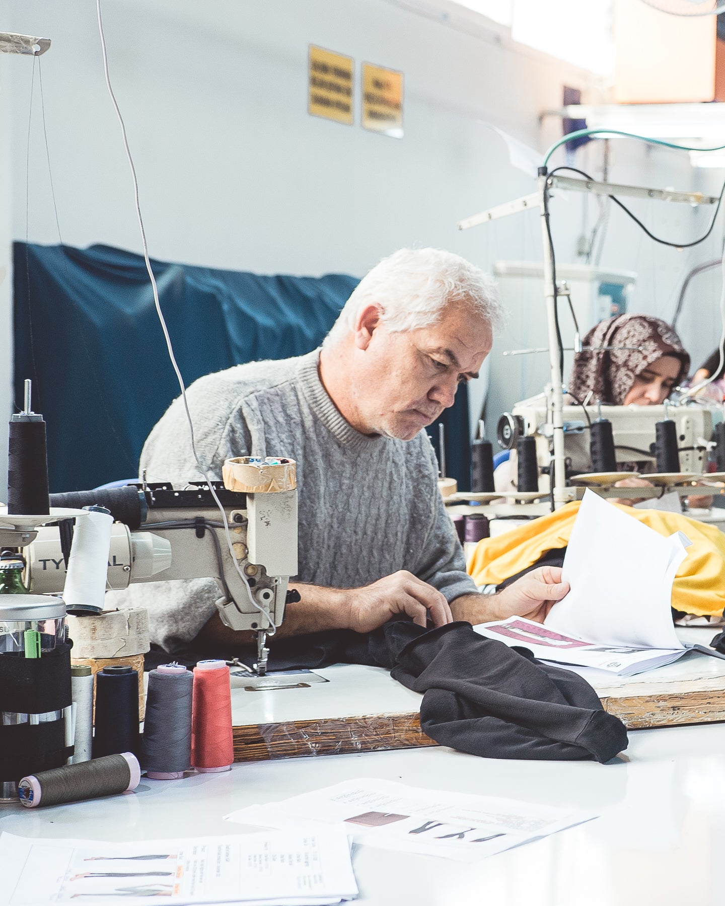 Man wearing jumper working on clothes